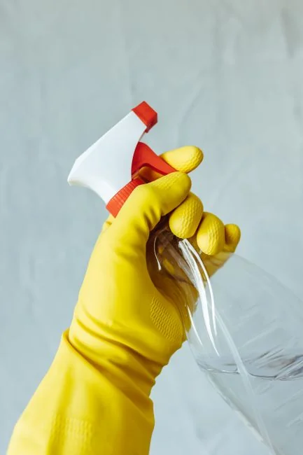A person in full PPE gear standing indoors, emphasizing disinfection during COVID-19.
